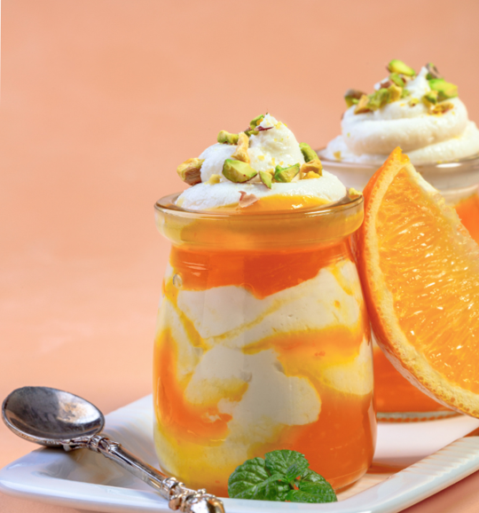 Orange yogurt parfait dessert with pistachios